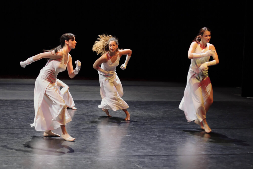 Group of contemporary dancers performing on stage.
