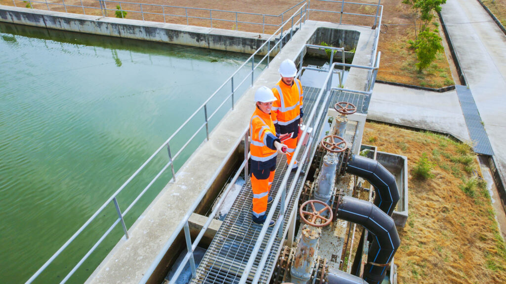 Aerial View of Two Environmental engineers work at wastewater treatment plants, Water management concept.