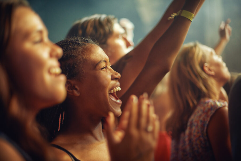 Young girls in an audience enjoying their favourite band's performance.
